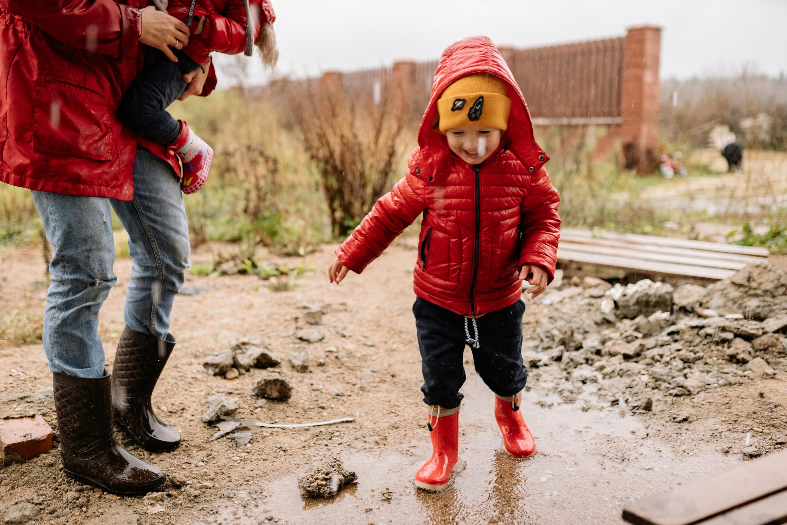 Enfant jouant dans la boue avec des vêtements adaptés